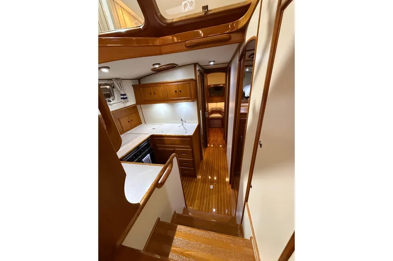 Slide: The Image of Interior of 2000 Grand Banks 43 Eastbay FB yacht, featuring elegant wood finishes and compact kitchen. - 91