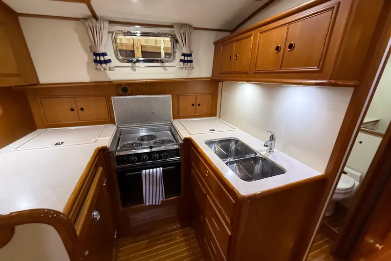 Slide: The Image of Galley kitchen in 2000 Grand Banks 43 Eastbay FB yacht with wood cabinetry and stainless steel sink. - 93