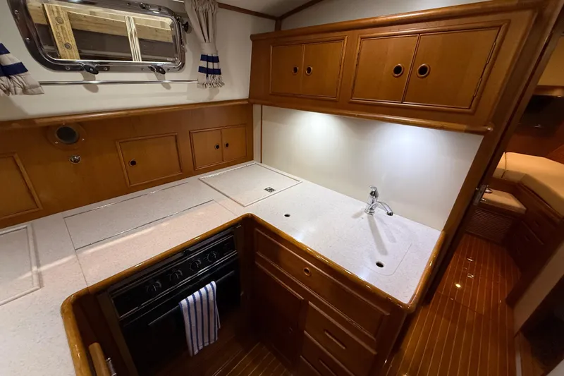 Slide: The Image of Luxurious 2000 Grand Banks 43 Eastbay FB yacht kitchen with wood cabinetry and modern amenities. - 97