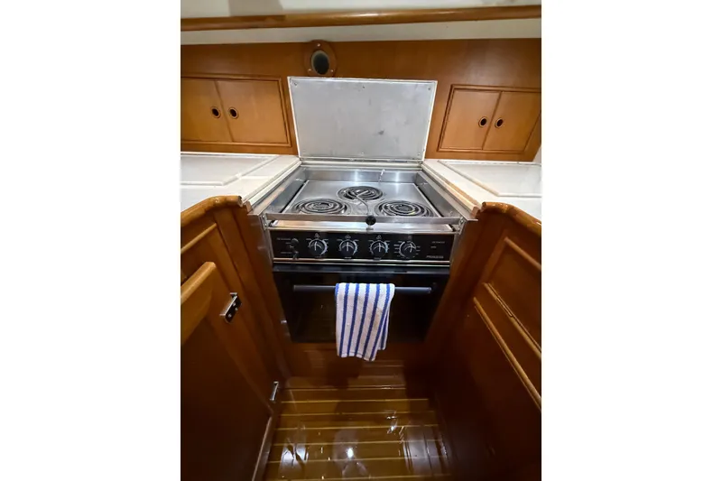 Slide: The Image of Galley kitchen in 2000 Grand Banks 43 Eastbay FB yacht with stove and wooden cabinetry. - 99