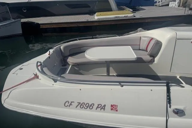 Slide: The Image of 1997 Sea Ray 240 Sundeck boat with seating and table, docked at marina. - 1