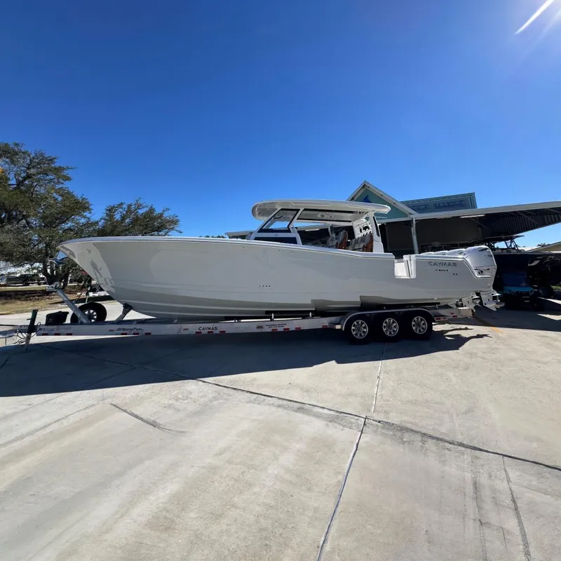 The Image of 2027 Caymas 401 CC boat on trailer under clear blue sky. - 0
