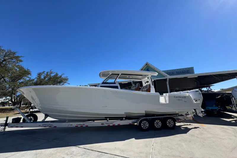 Slide: The Image of 2027 Caymas 401 CC boat on trailer under clear blue sky. - 1