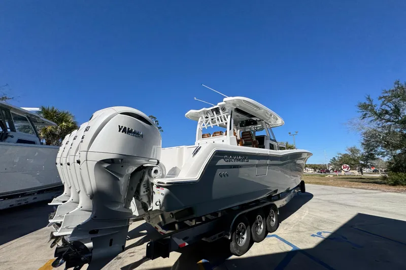 Slide: The Image of 2027 Caymas 401 CC boat with Yamaha engines on a trailer under clear blue sky. - 10