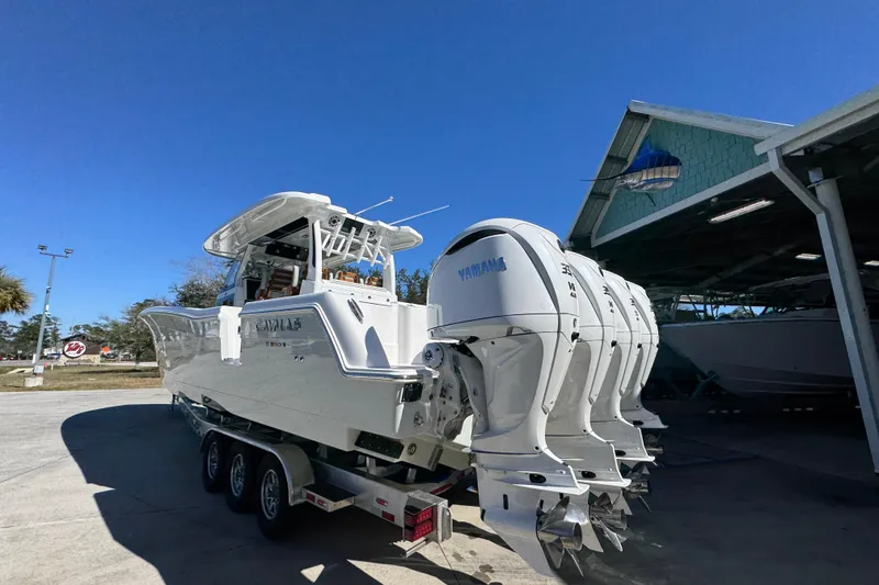 Slide: The Image of 2027 Caymas 401 CC boat with multiple Yamaha engines on a trailer, parked outdoors. - 13