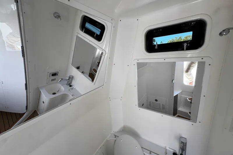Slide: The Image of Interior of 2027 Caymas 401 CC boat bathroom with sink, mirror, and window. - 27