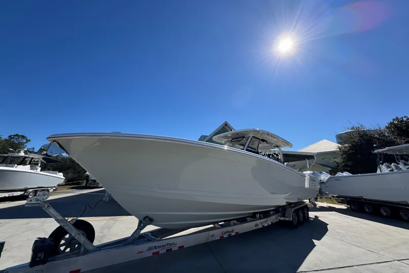 Slide: The Image of 2027 Caymas 401 CC boat on trailer under bright sunlit sky. - 3