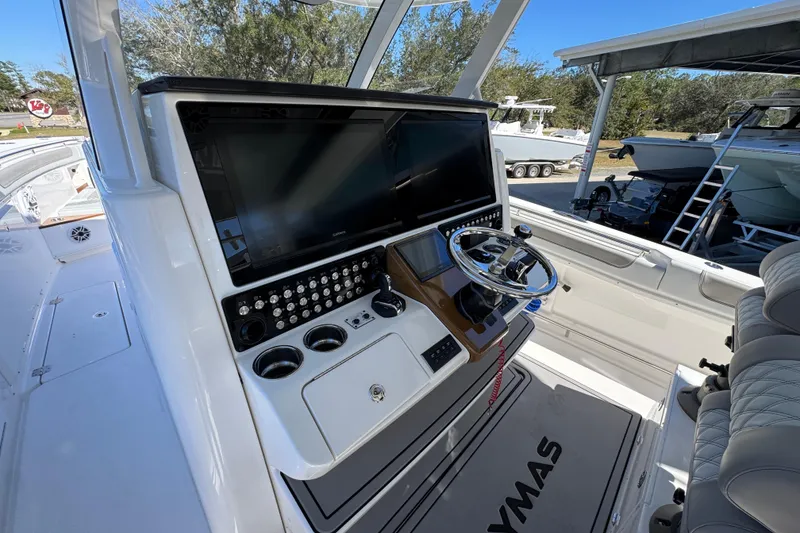 Slide: The Image of 2027 Caymas 401 CC boat cockpit with advanced navigation system and sleek steering wheel. - 38