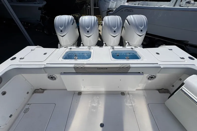 Slide: The Image of 2027 Caymas 401 CC boat with four powerful outboard engines, sleek design, and spacious deck. - 49