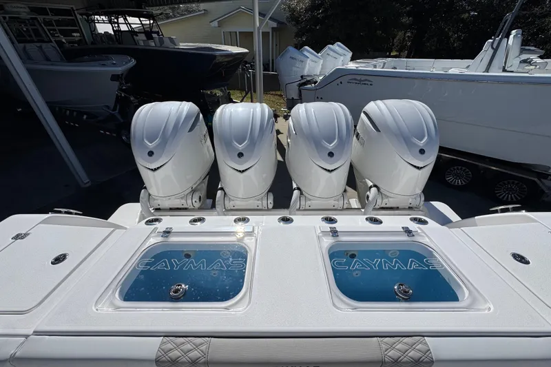 Slide: The Image of 2027 Caymas 401 CC boat with four powerful outboard engines, displayed in a showroom. - 50