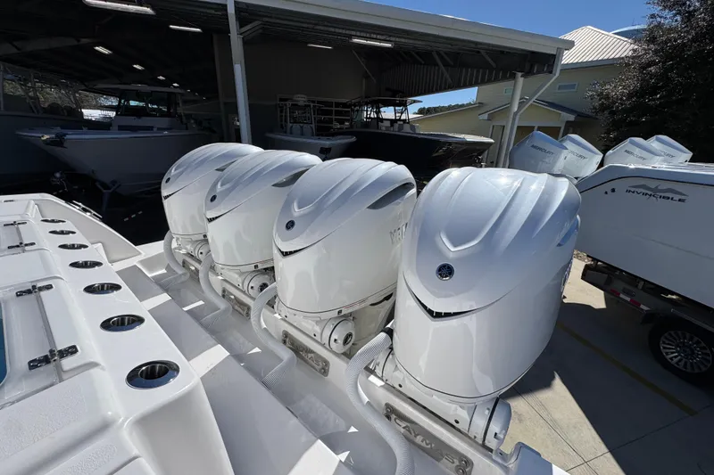 Slide: The Image of 2027 Caymas 401 CC boat with four powerful outboard engines in a marina. - 51