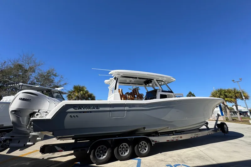 Slide: The Image of 2027 Caymas 401 CC boat on trailer under clear blue sky. - 9