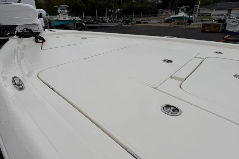 Slide: The Image of 2025 Skeeter SX241 boat deck with storage compartments, in a marina setting. - 27