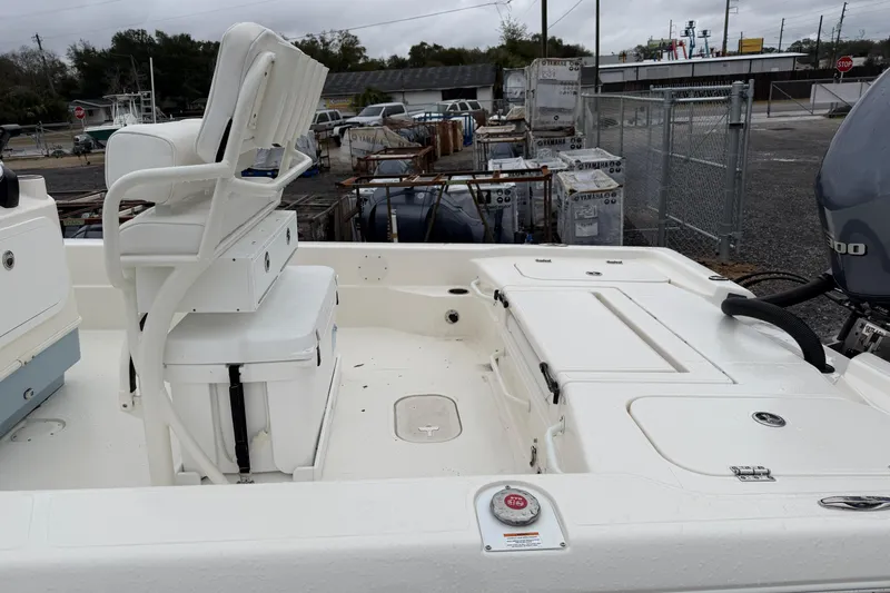 Slide: The Image of 2025 Skeeter SX241 boat interior with seating and storage, parked outdoors. - 32