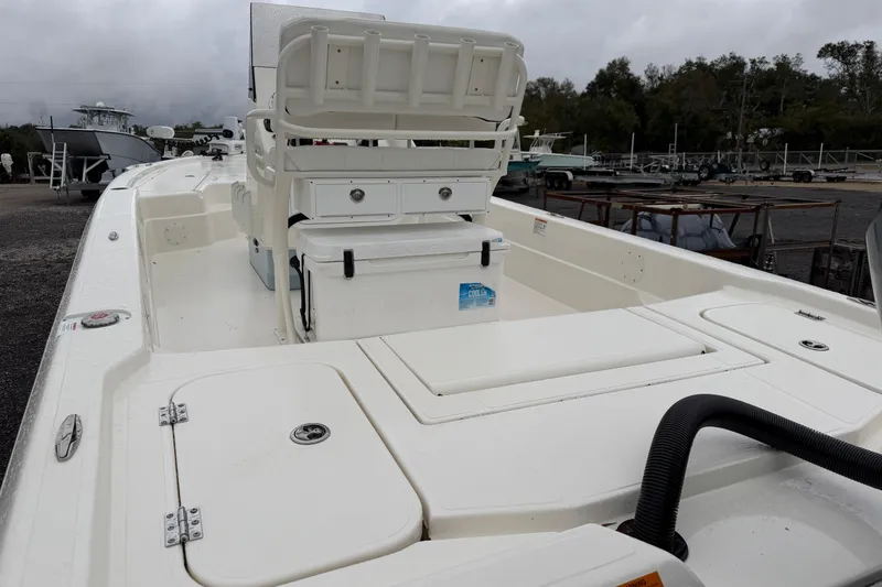 Slide: The Image of 2025 Skeeter SX241 boat interior with seating and storage compartments, docked outdoors. - 4