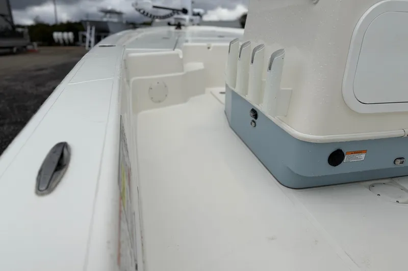 Slide: The Image of 2025 Skeeter SX241 boat interior with rod holders and storage compartment. - 49