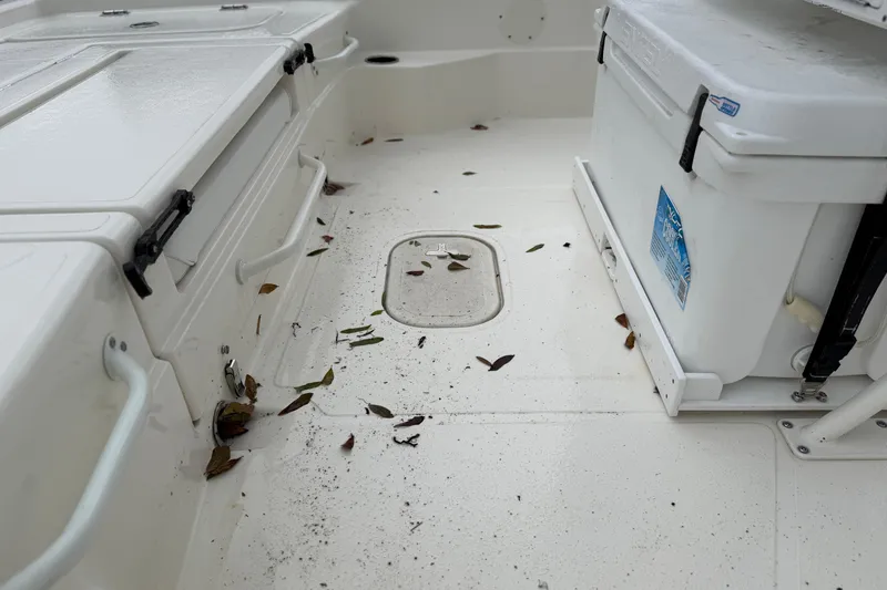 Slide: The Image of 2025 Skeeter SX241 boat deck with leaves and cooler. - 57