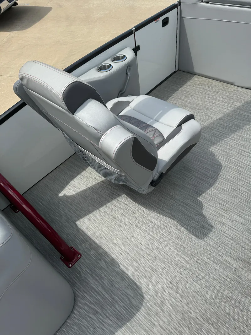 Slide: The Image of 2022 Bennington 28 QXFBA boat interior with gray captain's chair and cup holders. - 9