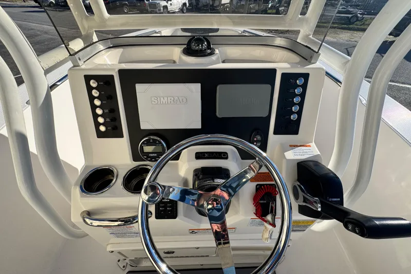 Slide: The Image of 2023 Robalo R202 Explorer boat dashboard with steering wheel and Simrad display. - 6