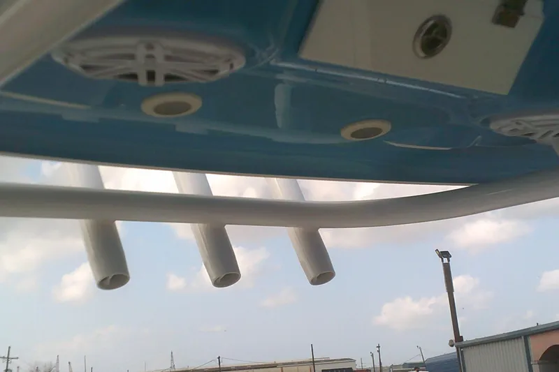 Slide: The Image of 2023 Sportsman Heritage 241 Center Console boat, featuring rod holders and speakers under a blue canopy. - 16