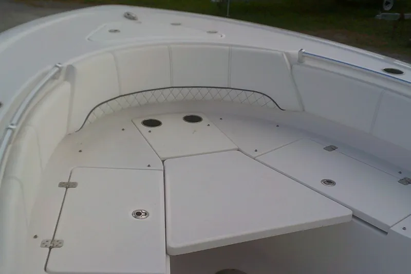 Slide: The Image of 2023 Sportsman Heritage 241 Center Console boat interior with white seating and storage compartments. - 6