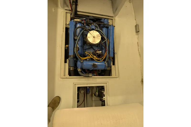Slide: The Image of 1963 Rybovich 22 boat engine, blue with visible wiring, in a white compartment. - 11