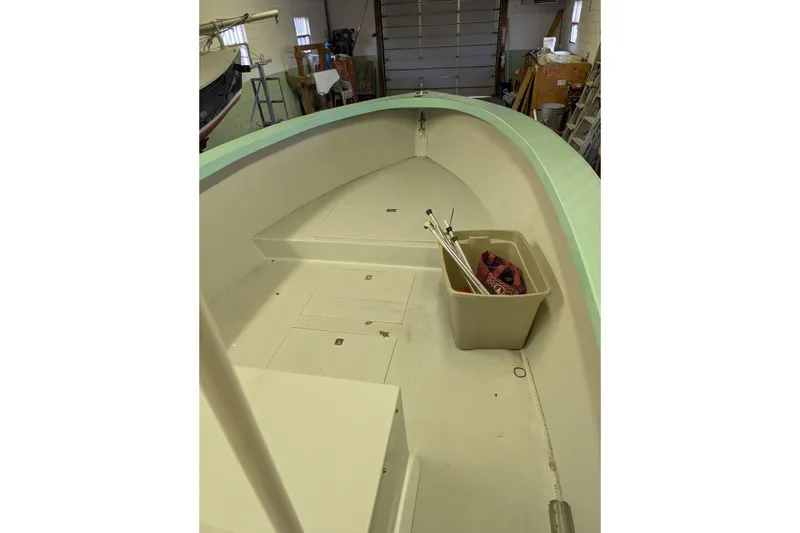 Slide: The Image of 1963 Rybovich 22 boat interior with storage bin and equipment in a workshop setting. - 13