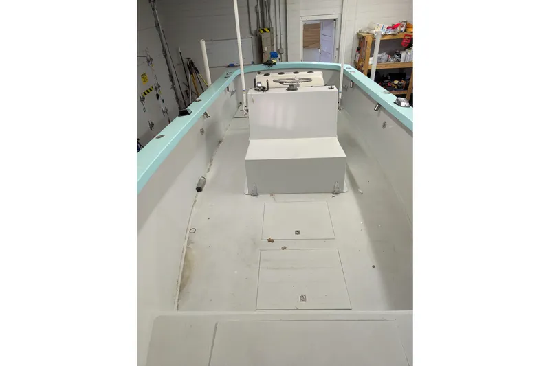 Slide: The Image of 1963 Rybovich 22 boat interior with white and teal accents in a workshop setting. - 14