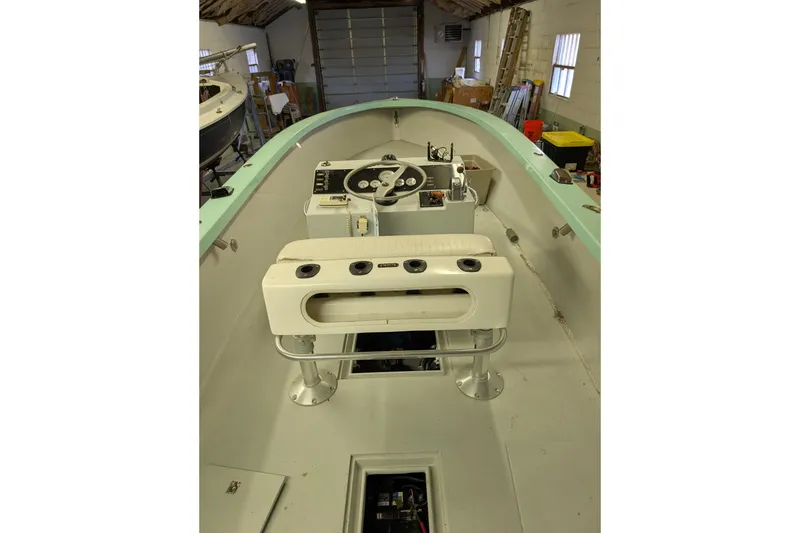 Slide: The Image of 1963 Rybovich 22 boat interior with steering console and seating in a garage. - 7