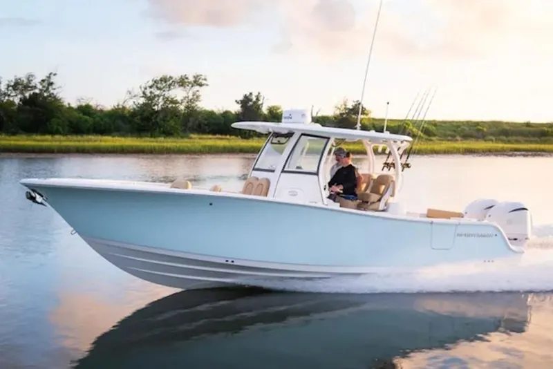 Slide: The Image of 2026 Sportsman Open 282 Center Console boat cruising on calm water at sunset. - 1