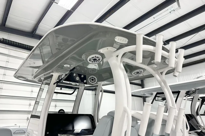 Slide: The Image of 2026 Sportsman Open 282 Center Console boat with T-top and rod holders in a showroom. - 8