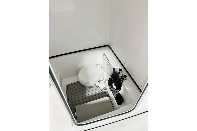 Slide: The Image of 2026 Sportsman Open 282 Center Console boat interior with toilet and storage area. - 9