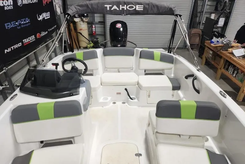 Slide: The Image of 2023 Tahoe T18 boat interior with gray and green seating, steering wheel, and storage compartments. - 3