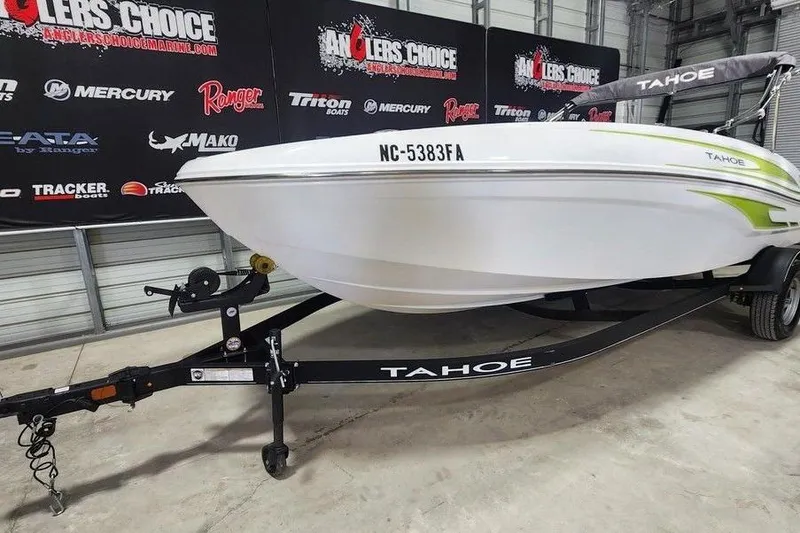 Slide: The Image of 2023 Tahoe T18 boat on trailer in showroom with promotional banners. - 5