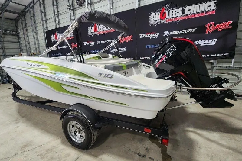 Slide: The Image of 2023 Tahoe T18 boat with green accents on a trailer in a showroom. - 6