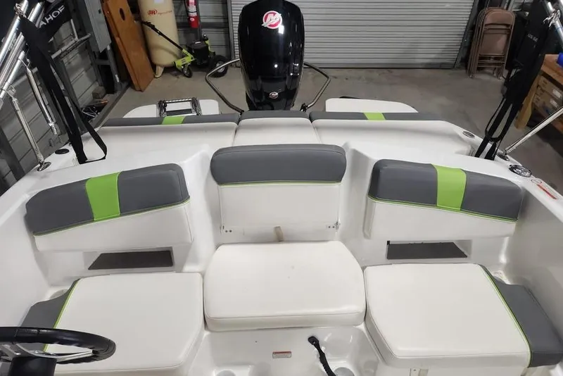 Slide: The Image of 2023 Tahoe T18 boat interior with gray and green seating in a garage setting. - 8