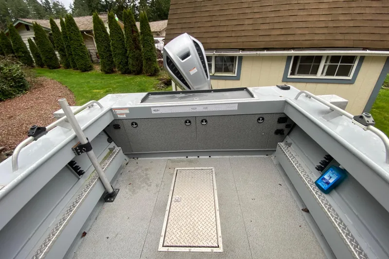 Slide: The Image of 2021 Hewescraft 210 Sea Runner ET Hardtop boat interior with storage and motor view. - 11