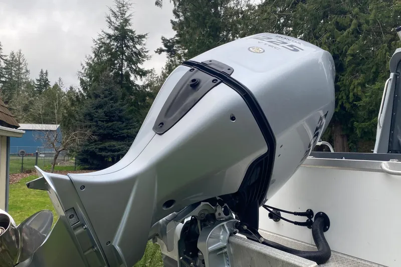 Slide: The Image of Outboard motor on 2021 Hewescraft 210 Sea Runner ET Hardtop, surrounded by trees. - 14