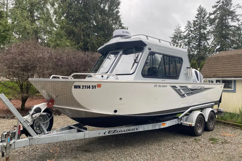 Slide: The Image of 2021 Hewescraft 210 Sea Runner ET Hardtop on trailer, surrounded by trees and a house. - 3