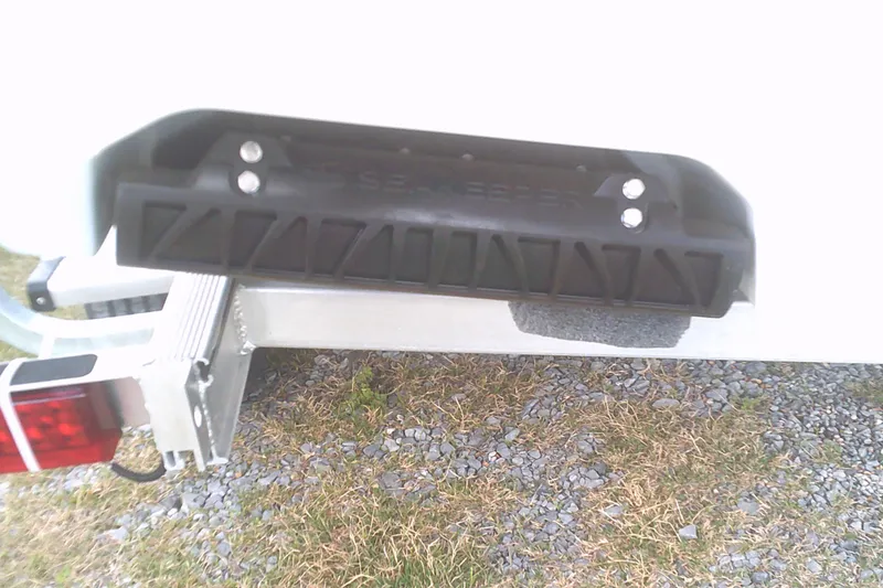 Slide: The Image of 2025 Sportsman Masters 227 Bay Boat trailer hitch on gravel and grass. - 3