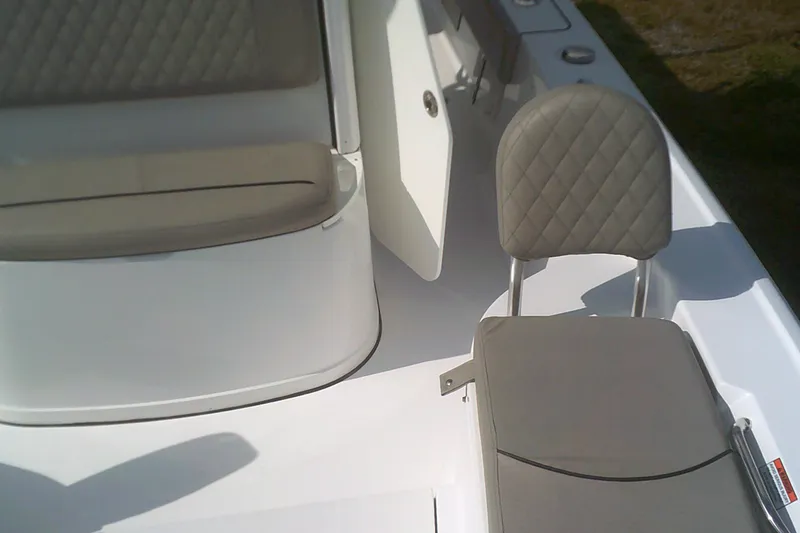 Slide: The Image of 2025 Sportsman Masters 227 Bay Boat interior with cushioned seating and storage compartment. - 7