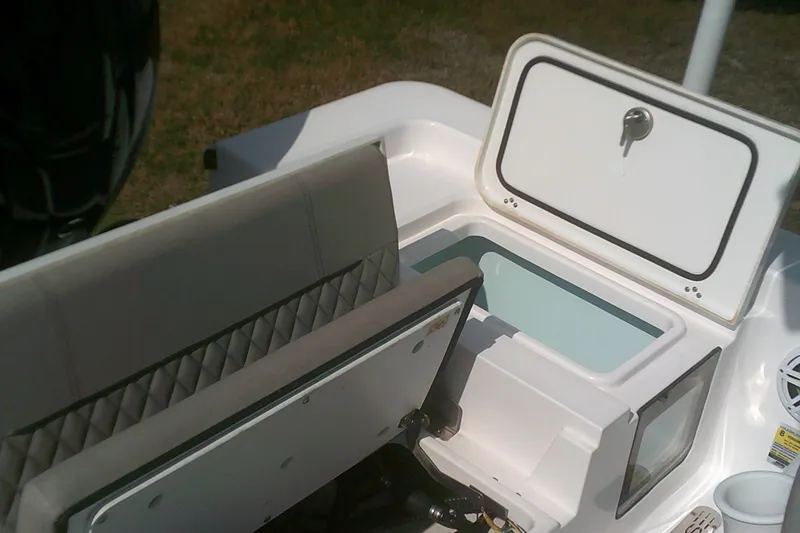 Slide: The Image of 2025 Sportsman Masters 227 Bay Boat interior with open storage compartment and seating. - 11