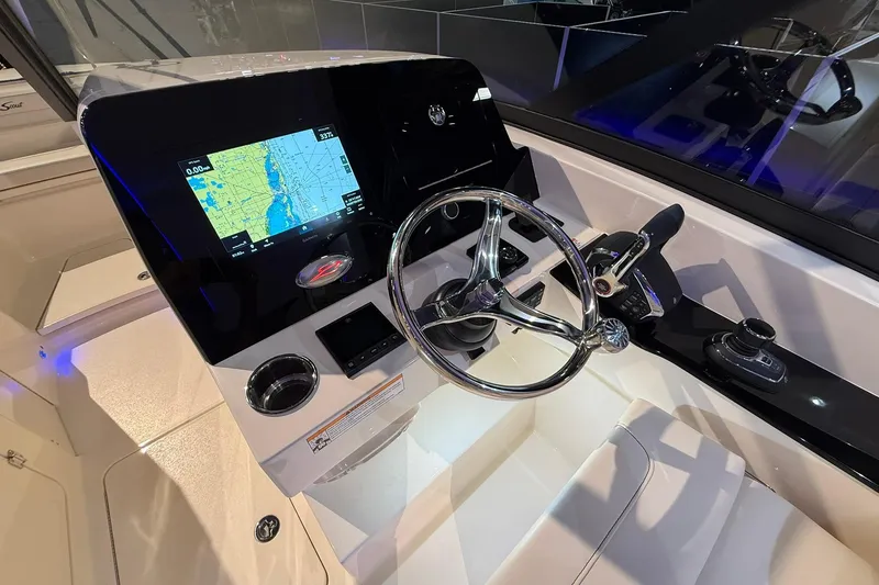 Slide: The Image of 2026 Scout 288 Dorado boat dashboard with navigation screen and steering wheel. - 10