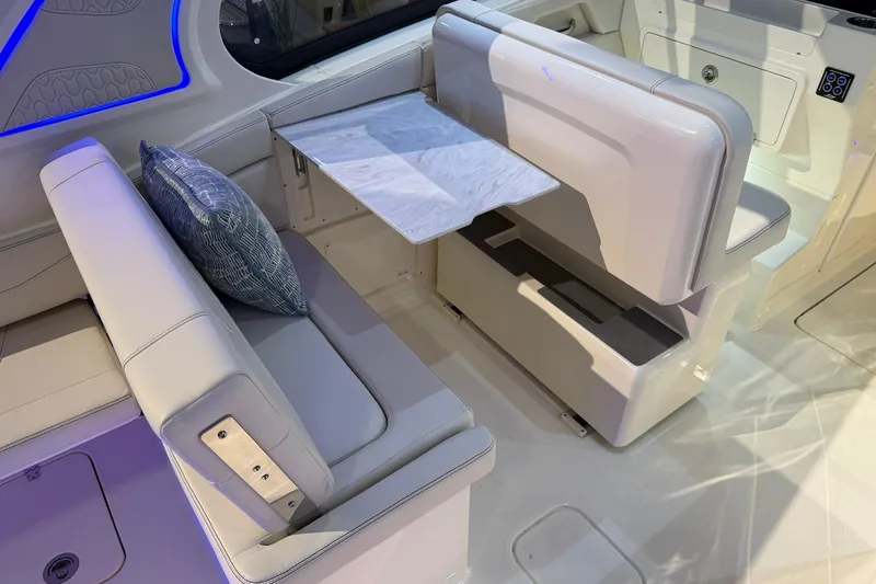 Slide: The Image of 2026 Scout 288 Dorado boat interior with white seating and a foldable table. - 15