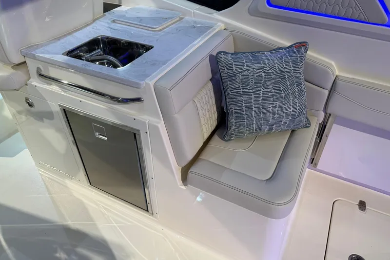Slide: The Image of 2026 Scout 288 Dorado boat interior with sink, cushioned seating, and decorative pillow. - 18
