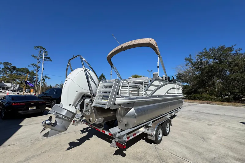 Slide: The Image of 2026 Bennington 22 MSB pontoon boat on trailer under clear blue sky. - 11