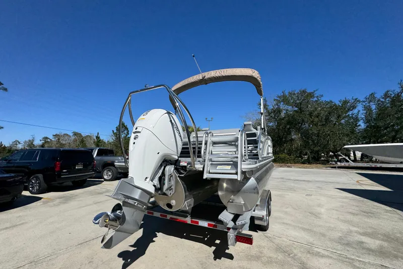 Slide: The Image of 2026 Bennington 22 MSB pontoon boat with outboard motor in a parking lot. - 12