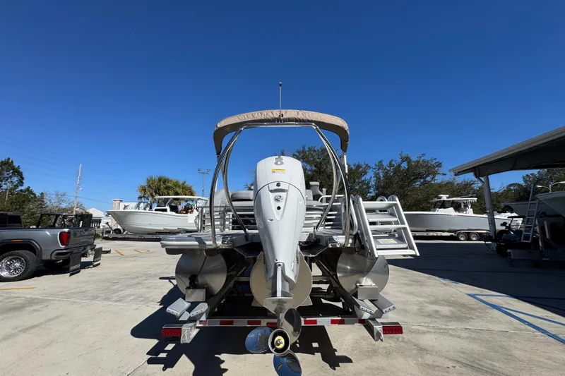 Slide: The Image of 2026 Bennington 22 MSB pontoon boat with outboard motor in a sunny marina. - 13