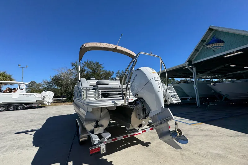 Slide: The Image of 2026 Bennington 22 MSB pontoon boat with outboard motor on trailer, sunny day. - 14