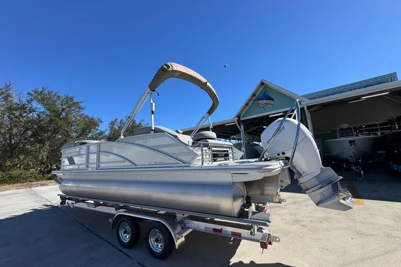 Slide: The Image of 2026 Bennington 22 MSB pontoon boat on trailer, parked outdoors under clear blue sky. - 15